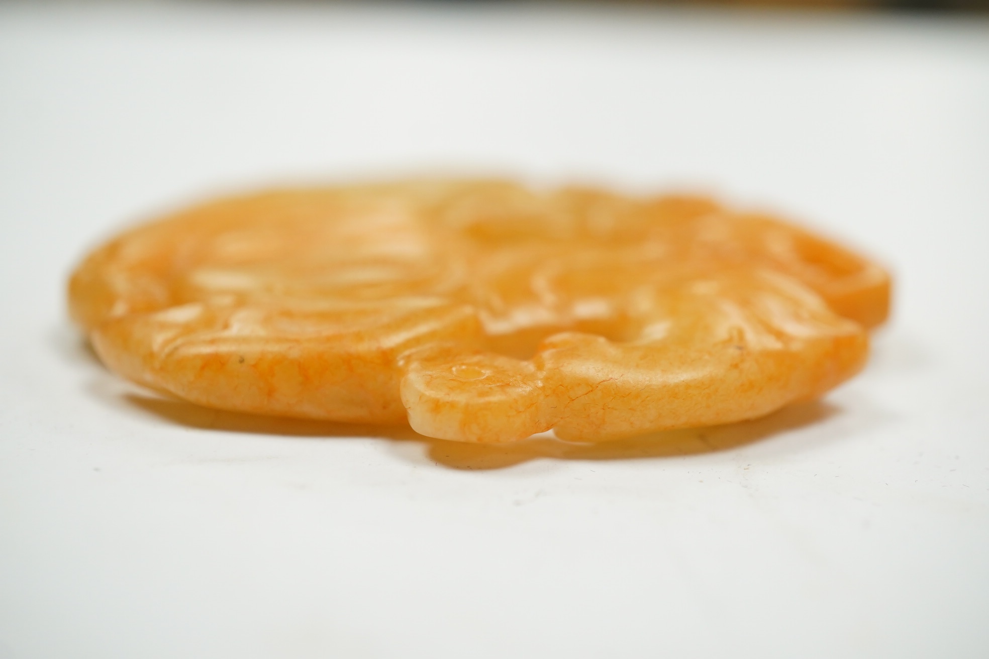 A Chinese russet and green jade bi disc and another plaque, largest 7cm diameter. Condition - good